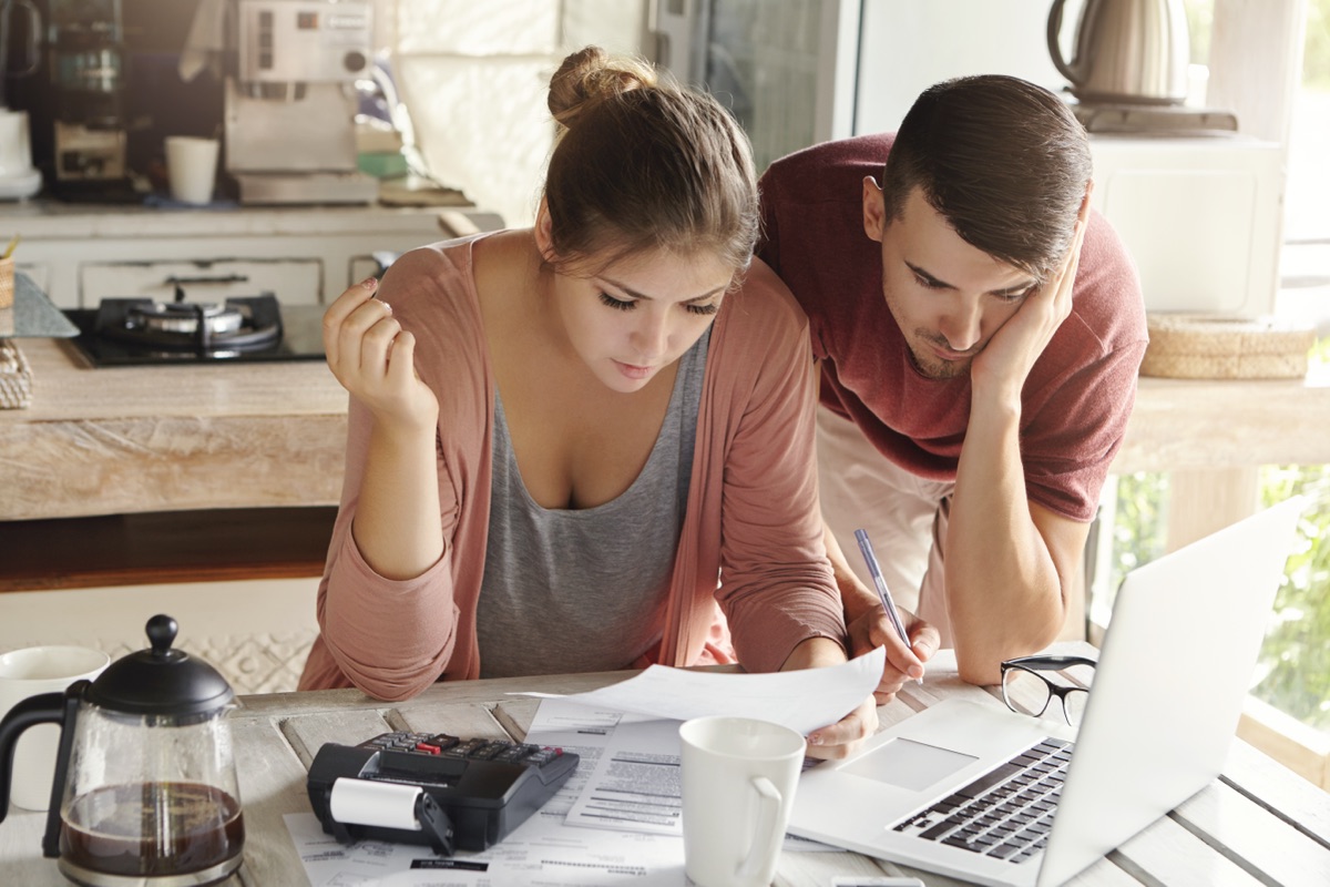 California couple reviewing mortgage refinancing options and financial documents to determine the best time to refinance their home